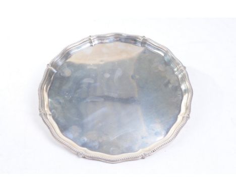 A George V silver tray
Of scalloped circular form with beaded borders, with flat base, unidentified maker, Sheffield, 1905, a