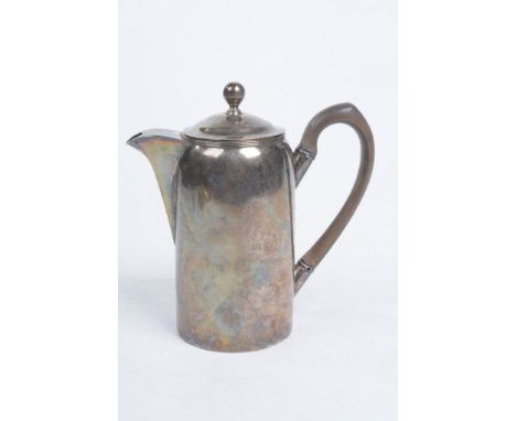 A George III silver coffee pot
The straight side pot extending to a domed cover and fluted spout, engraved with heraldic cres