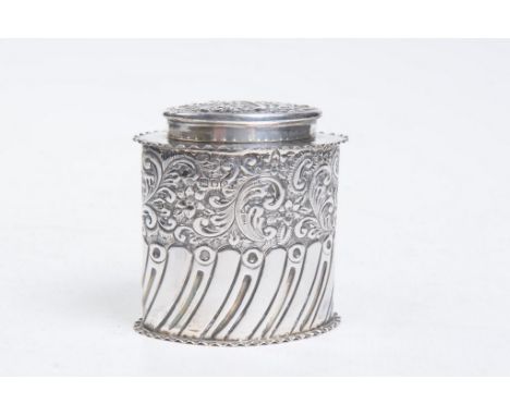 A Victorian silver tea caddy
Of oval form, surmounted by a domed cover, chased and engraved with half fluted designs, below f