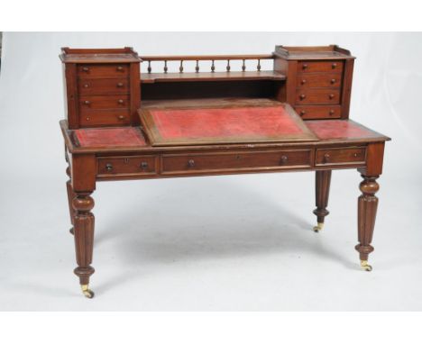 A Victorian mahogany clerks desk
The raised back with a spindle gallery above a concave shelf flanked by pedestals enclosing 