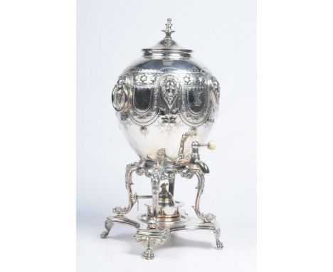 A Victorian silver-plated samovar
The ornately cast hot water receptacle cast with a series of masks and twin swing handles, 