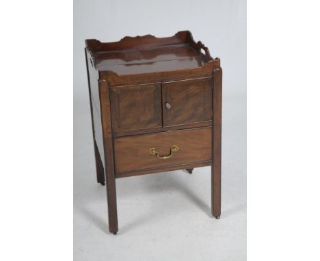 A George III mahogany bedside cupboard
With a shaped tray top with kidney shaped apertures above a pair of cupboard doors, no