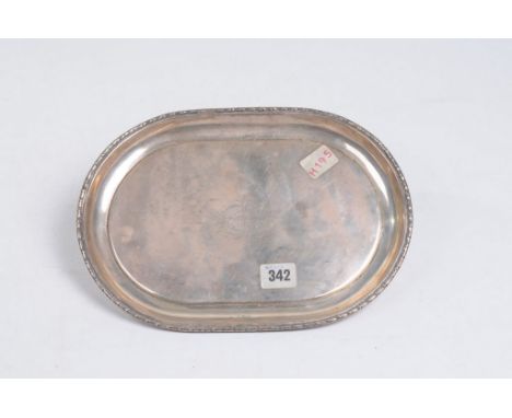 An early 20th Century silver tray
Of palin rounded oval form with flowerhead borders and plain central field, 30cm long, 21cm