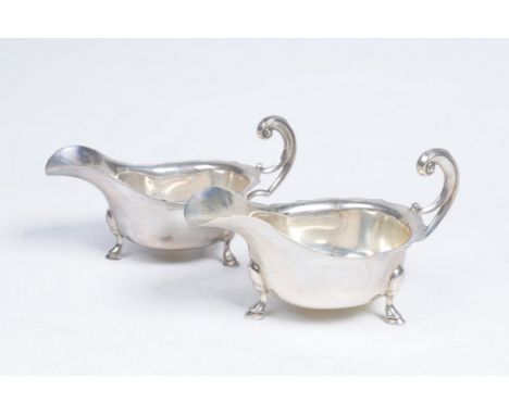 A pair of George V silver sauce jugs
Each of circular scalloped form with shaped spout and high scroll loop handle, 5cm high,