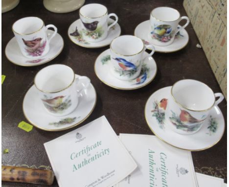 A set of six Royal Worcester Compton and Woodhouse coffee cans and saucers, decorated with birds, with certificates