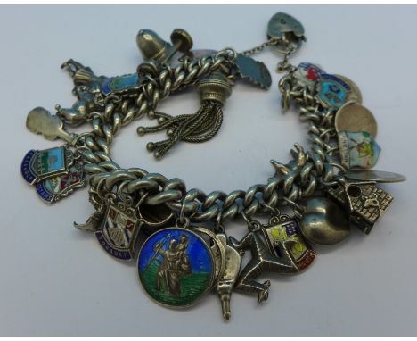 A silver charm bracelet with thirteen charms, two Victorian coins and fourteen silver and enamel charms, 89g