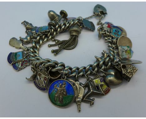 A silver charm bracelet with thirteen charms, two Victorian coins and fourteen silver and enamel charms, 89g