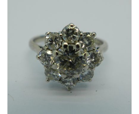 An 18ct gold, nine stone diamond cluster ring on white gold, Birmingham 1977, centre stone approximately .80ct plus eight sur