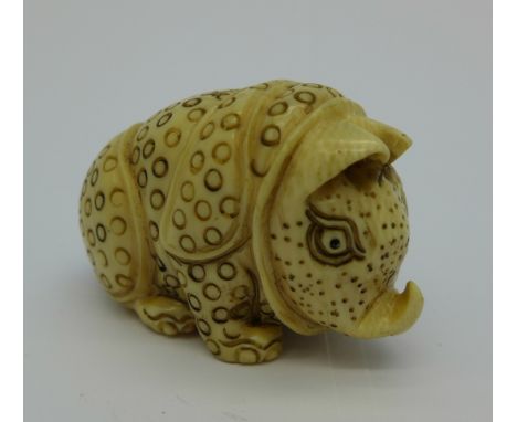 A carved ivory stylised rhinoceros netsuke, c.1920, signed