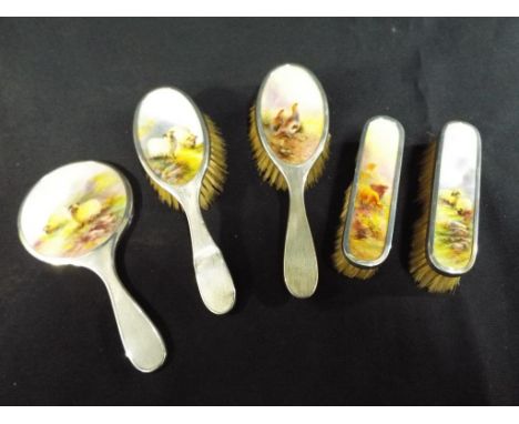A hallmarked silver five piece dressing table set with hallmarked silver mounts, each piece set with a hand painted Royal Wor