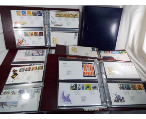 Six Royal Mail albums containing a good collection of UK First Day Covers and a Royal Mail wooden chest containing further po
