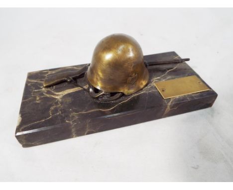 A memorial plaque with German helmet and rifle on marble base, 6.5 cm (h) x 14.8 cm (w) x 6.8 cm (d) - Est £40 - £60