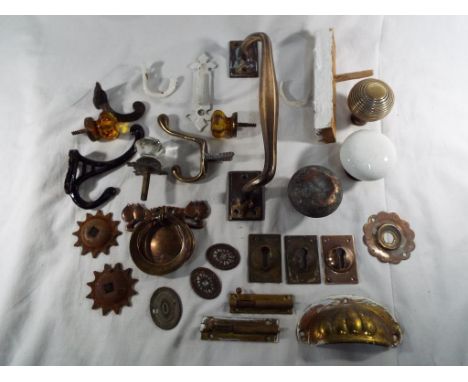 A large quantity of antique brass door fittings to include handles, hooks and an art nouveau door knocker, included in the lo