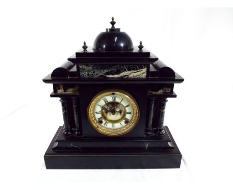 A black marble cased mantel clock, the architectural case having contrasting decorative marble panels, flanked by four turned