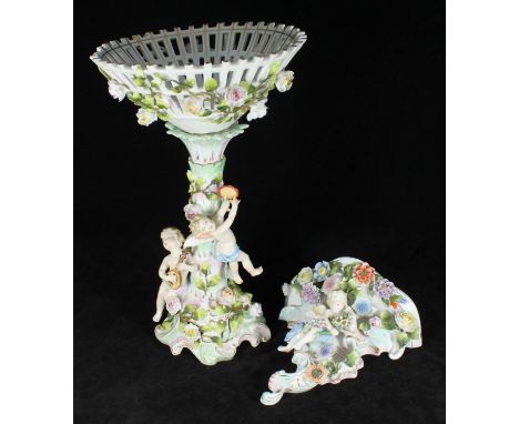A 19th century German porcelain comport, modelled with a conical pierced basket, supported by cherubs playing instruments, ar