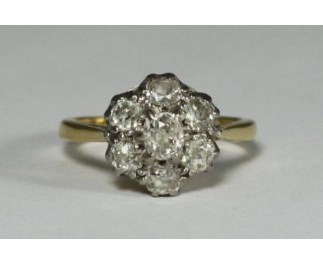 An 18ct gold and diamond cluster ring, set with a central old cut diamond surrounded by six small old cuts diamonds, approxim