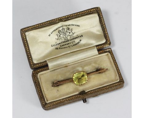 A yellow metal (tests as 9ct gold) brooch, centrally claw set with a rectangular faceted light green stone, gross weight appr