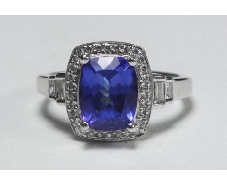 An 18ct white gold, Tanzanite and diamond ring, centrally claw-set with a rectangular cushion cut Tanzanite, approx. 3.10 car