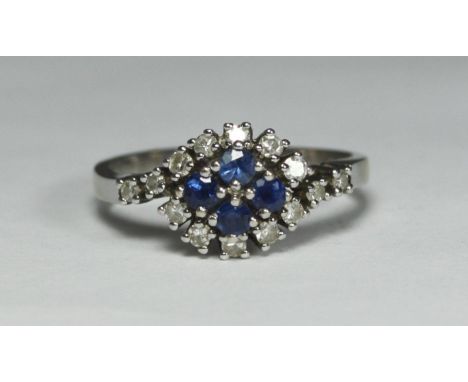 An 18ct white gold crossover style ring, set with four sapphire coloured stones and fourteen diamonds, total diamond weight a