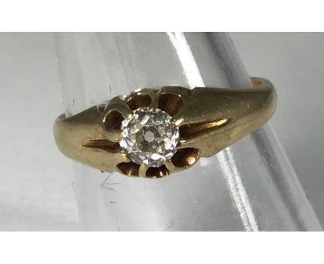 A yellow metal (tests as 14ct gold or above) gents ring, the top centrally claw set with a round, transitional cut diamond, t