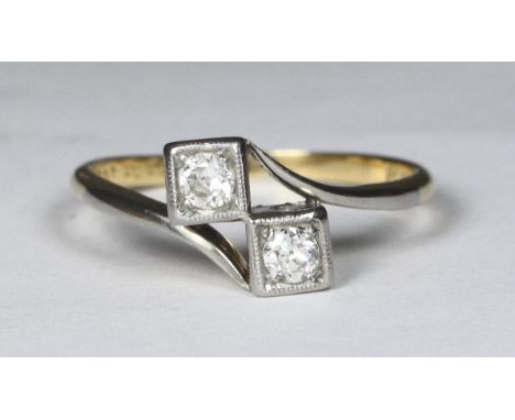 An 18ct gold and platinum two-stone diamond ring, crossover design, square settings rbc diamonds, 0.15pts, 2.8g 