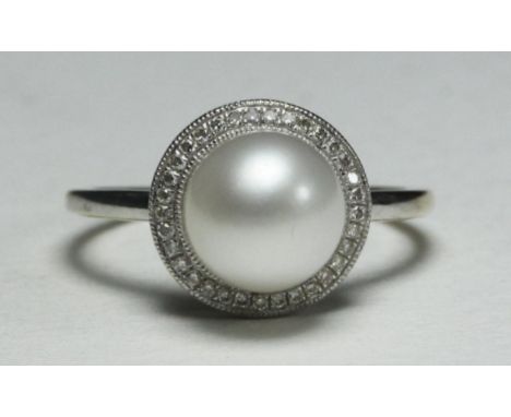 A 9k white gold ring centrally-set with a single pearl surrounded by 33 small diamonds, 2.6g 