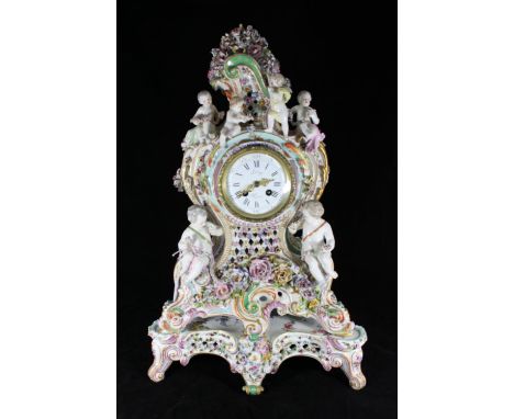 A 19th Century German porcelain clock garniture, in the Rococo revival style, with French eight-day movement striking a bell,