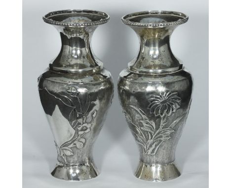 A pair of early 20th century Chinese Export silver vases of baluster form embossed and chased with flowering foliage around u