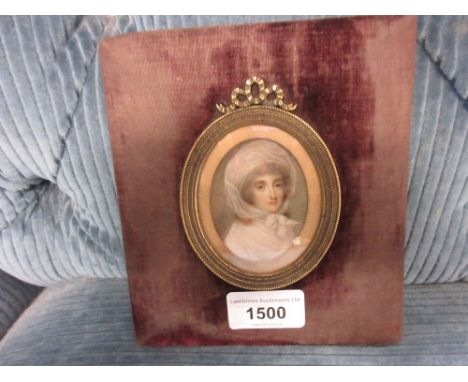 Early 19th Century oval head and shoulder portrait miniature of a lady, unsigned, housed in an oval gilt metal and velvet cus