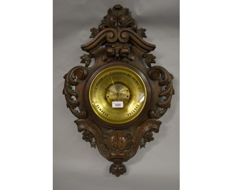 19th Century French carved oak aneroid barometer, the pierced floral cartouche case with inset brass dial and visible mechani
