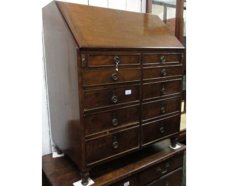 Early 20th Century mahogany bureau, the fall front enclosing a fitted interior above an arrangement of ten drawers with brass