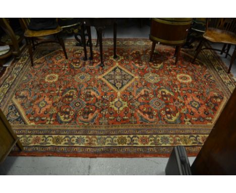 Mahal carpet with a medallion and all-over stylised floral design on a red ground with borders (slight areas of wear), 311cms