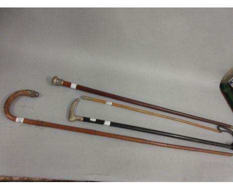 Two silver mounted walking sticks, another with white metal mount and a swagger stick 