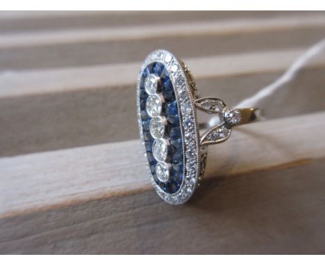 Platinum ring set five vertical graduated diamonds surrounded by calibre cut sapphires 