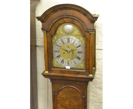 Figured walnut longcase clock, the broken arch hood with flanking pilasters above a moulded panel door and conforming plinth 