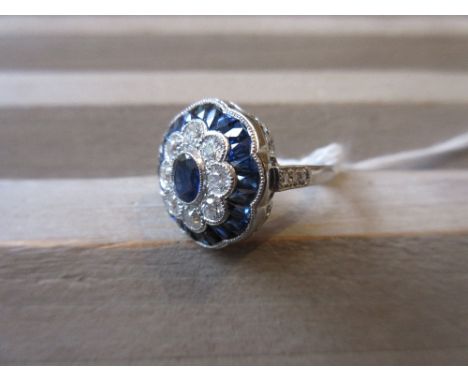 Platinum ring set central oval sapphire surrounded by diamonds and calibre cut sapphires 