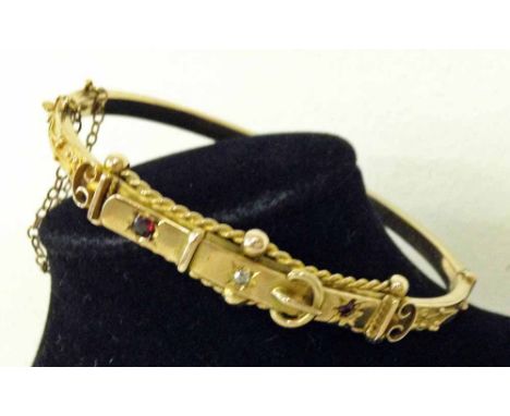 A 9ct gold Victorian bangle designed as a belt buckle and set with a diamond and 2 rubies.
