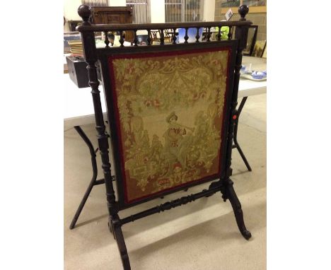 A large Victorian tapestry fire screen with turned wood supports and stretcher and galleried top.