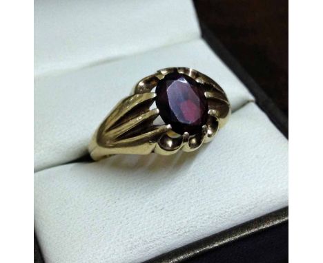 A vintage 9ct gold 'gypsy' ring set with an oval garnet. Approx 5.1g, size V.