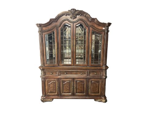 Kevin Charles - American walnut display cabinet, illuminated interior, shell carved pediment above four bevel edge doors encl
