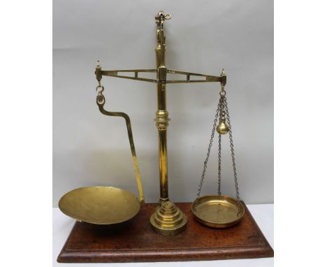 A late Victorian brass balance beam scale, raised on a polished mahogany base, by 'McClean &amp; Co., Newcastle', together wi