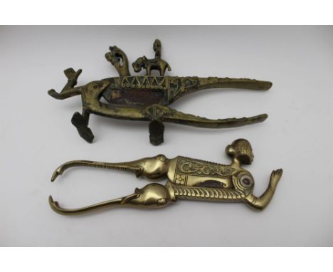 Two South Asian betel nut cutters, one with contemplative head and hands in prayer, together with elephant trunk handles (2) 