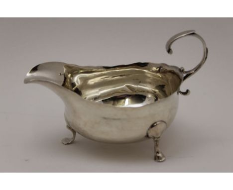 A Georgian Newcastle silver sauce boat, scroll handle, raised on three feet, marks partially worn, makers possibly John Langl