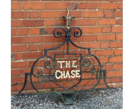 A 20th century wrought iron house sign, 'The Chase', black painted scroll work, with gilded flower finial &amp; gilded letter