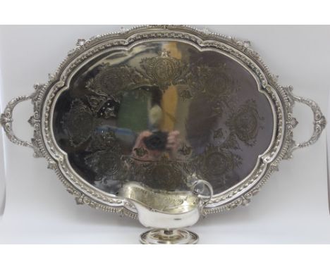 A silver plated two handled tea tray, with cast &amp; engraved decoration, 63.5cm overall, together with a plated spoon warme