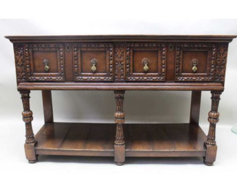 A Jacobean design oak side table, fitted two carved moulded front drawers with knob handles, on bulbous turned front legs, un