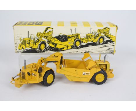 NZG - A boxed CAT 627 Push-Pull Scurfzug scraper in 1:50 scale. # 127. The model appears in Near Mint condition with only a f