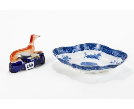 A 19TH CENTURY STAFFORDSHIRE POTTERY RECUMBENT GREYHOUND QUILL HOLDER, 5 ins long and a 19th Century spode blue and white tra