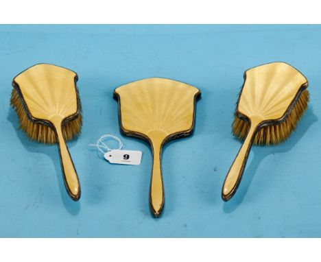A GEORGE V SILVER AND YELLOW ENAMEL HAND MIRROR and a pair of matching HAIR BRUSHES, maker: WGS LTD, Birmingham, 1931.   