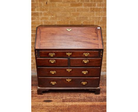 A GEORGE II MAHOGANY BUREAU the fall front enclosing a stepped interior above one long, two short and two long drawers raised